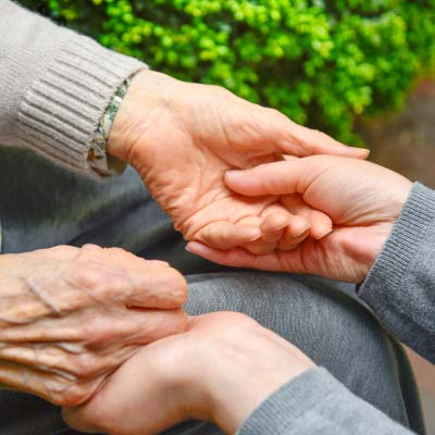 介護のイメージ写真 若い女性がお年寄りの女性の手を握る